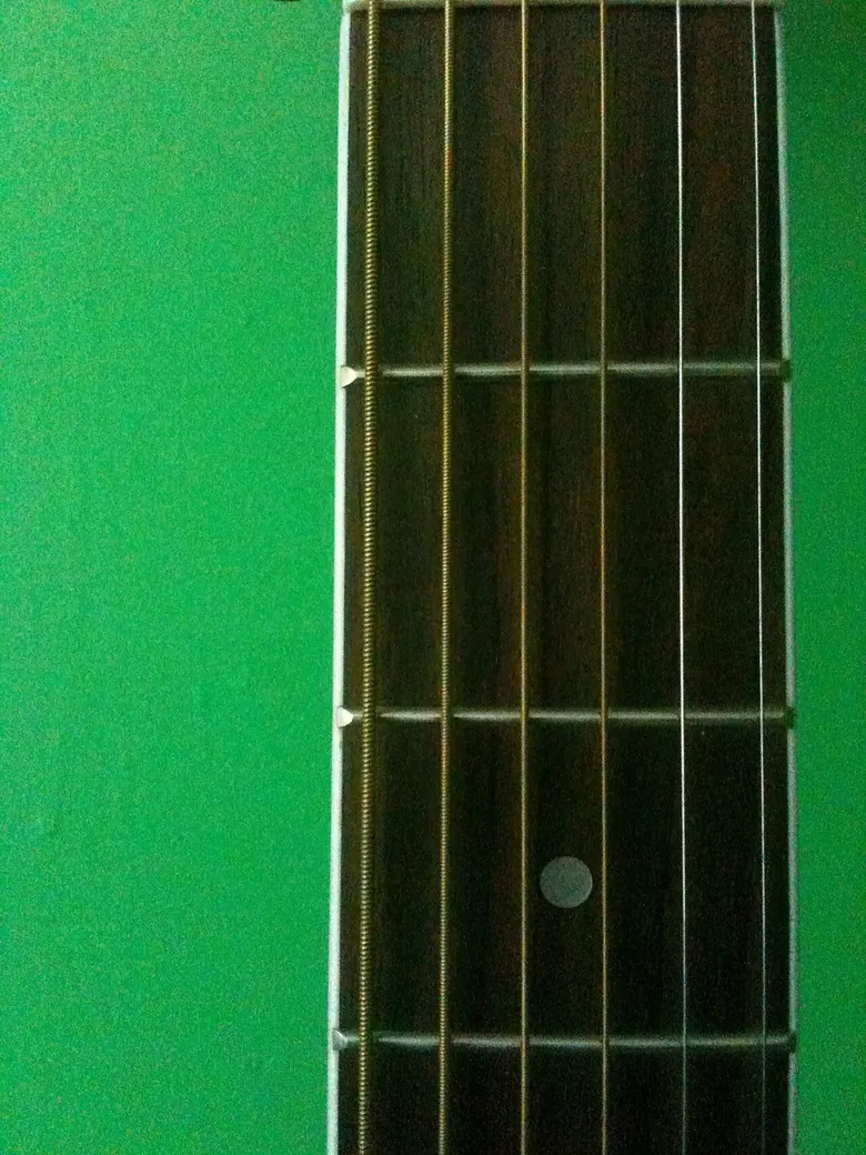 Eine Nahansicht eines Gitarrengriffbretts und der Bünde, nützlich zur Überprüfung des Oberflächenzustands und der Bundkanten.