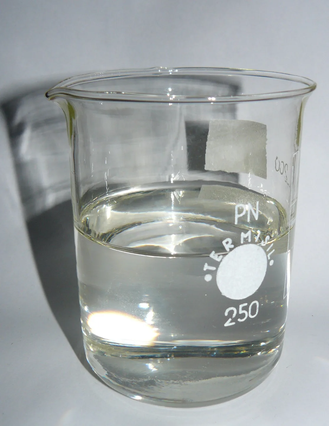Flüssiges Paraffin in einem Becher, das Mineralöl als Inhaltsstoff und nicht als spezifisches Pflegemittel darstellt.