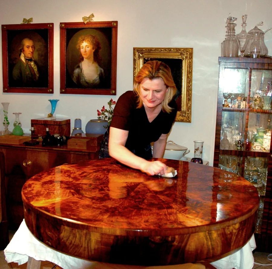 Ein Restaurator, der von Hand Schellackpolitur aufträgt und die French-Polishing-Technik veranschaulicht.