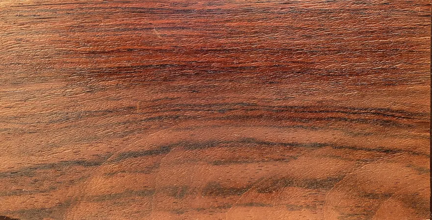 Ein dunkel gemasertes brasilianisches Palisanderholzmuster, fotografiert als geöltes Furnier, um sein Aussehen zu veranschaulichen.